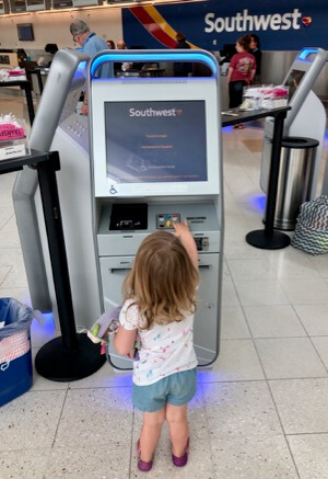 Young Southwest Companion Pass Holder Taking Ticket at the Kiosk